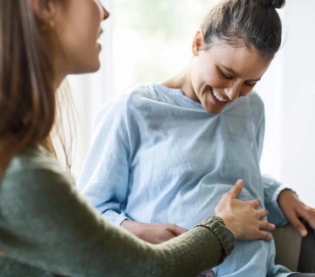 Intended mother touching a surrogate's belly